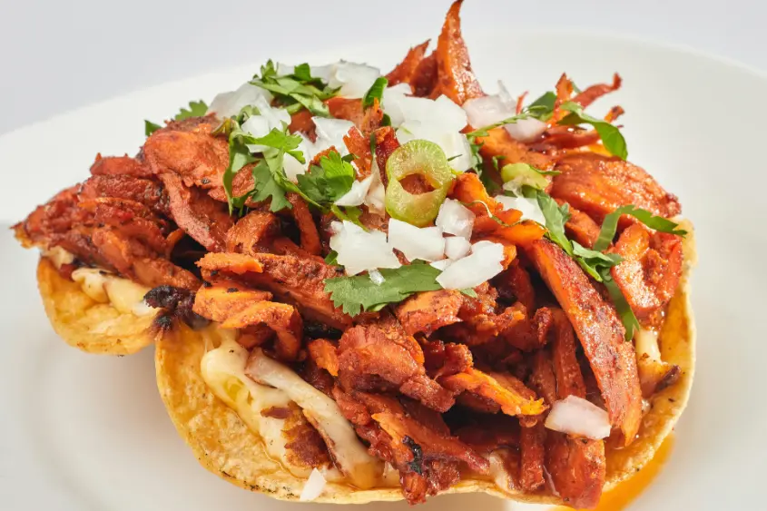 Authentic tacos al pastor with pineapple on a trompo in Mexico City