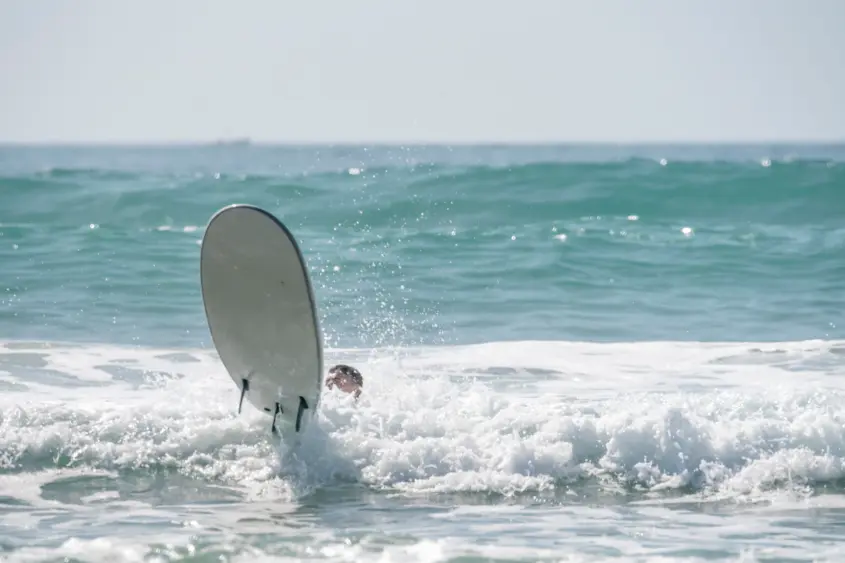 Beginner surfer taking a surf lesson on Kuta Beach Bali