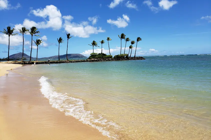 Happy kids playing on a calm sandy beach during a family vacation