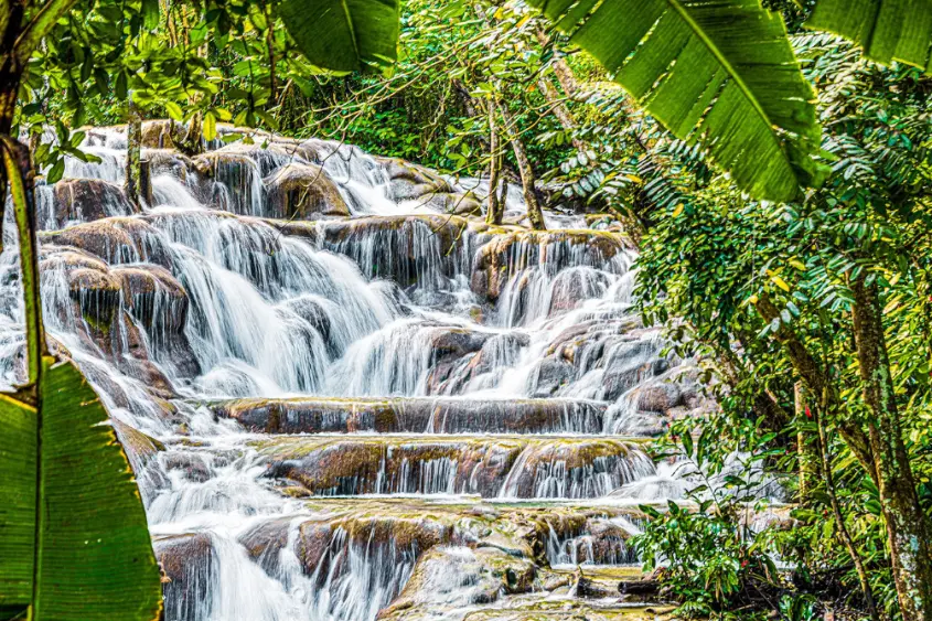 Tourists climbing Dunn's River Falls in Ocho Rios Jamaica on a sunny day